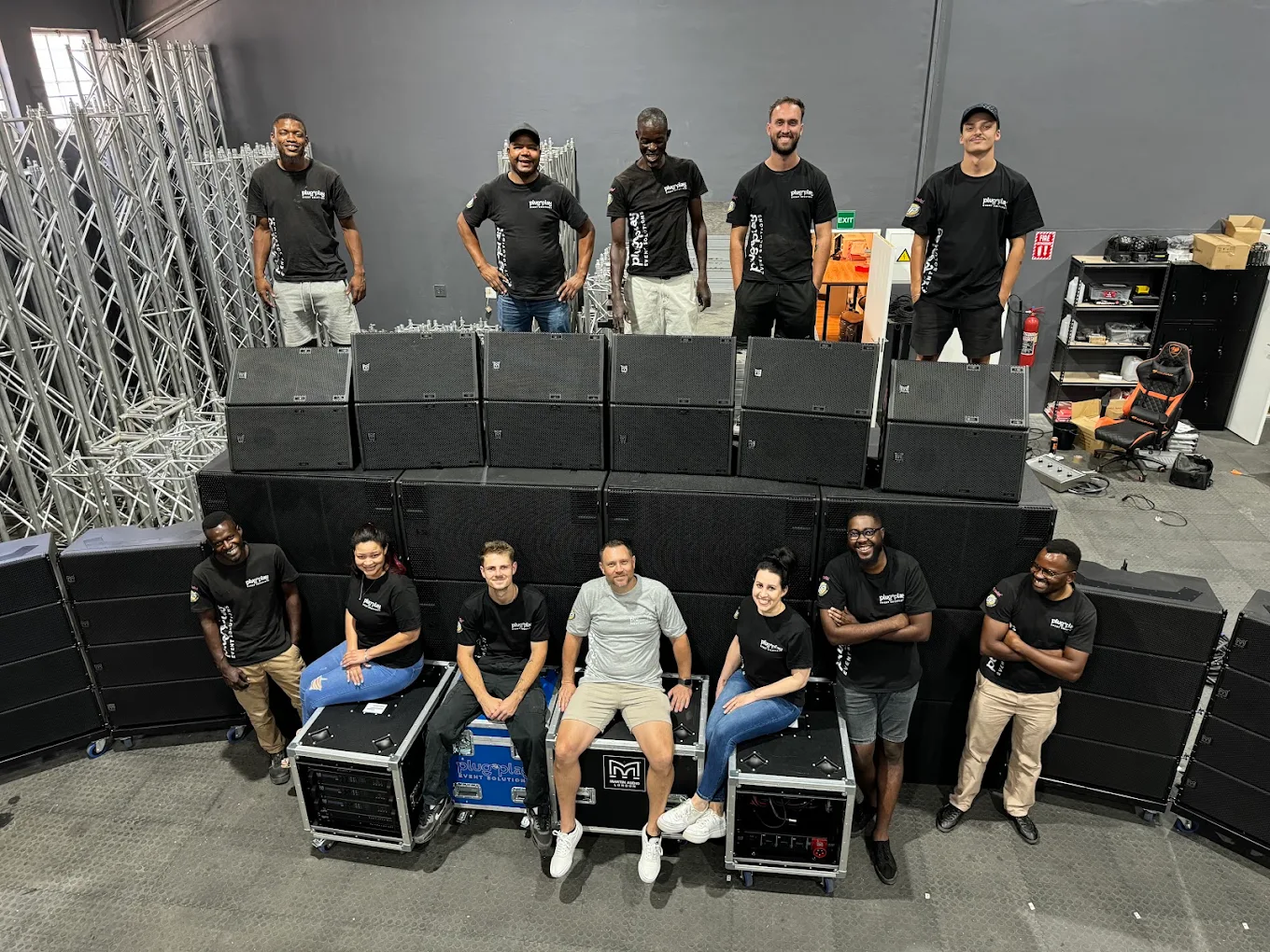 The Plug & Play crew posing with their line array PA system and flight cases